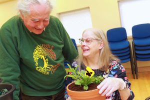 Tim Gee of Mousehold Garden Centre helps Annabel Clifton plant up her pot